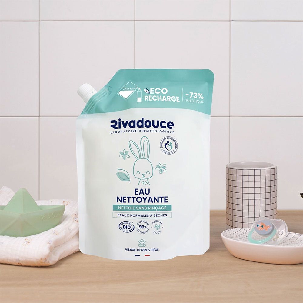 Recharge. Sachet blanc, bouchon vert. Inscription: logo, lapin, "Eau nettoyante", certification BIO. Arrière-plan: salle de bain.