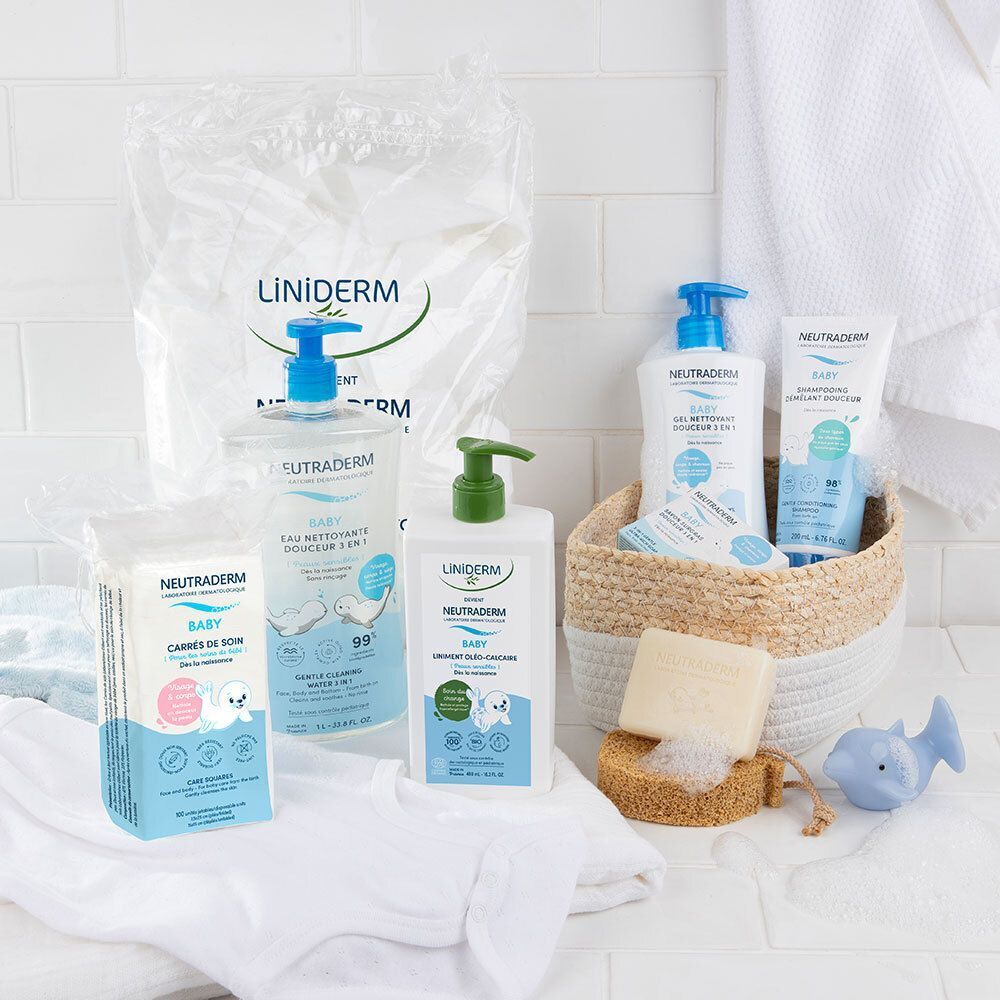 Divers produits Neutraderm sur une surface blanche. Bouteilles, tampons, savon et éponge dans un panier.