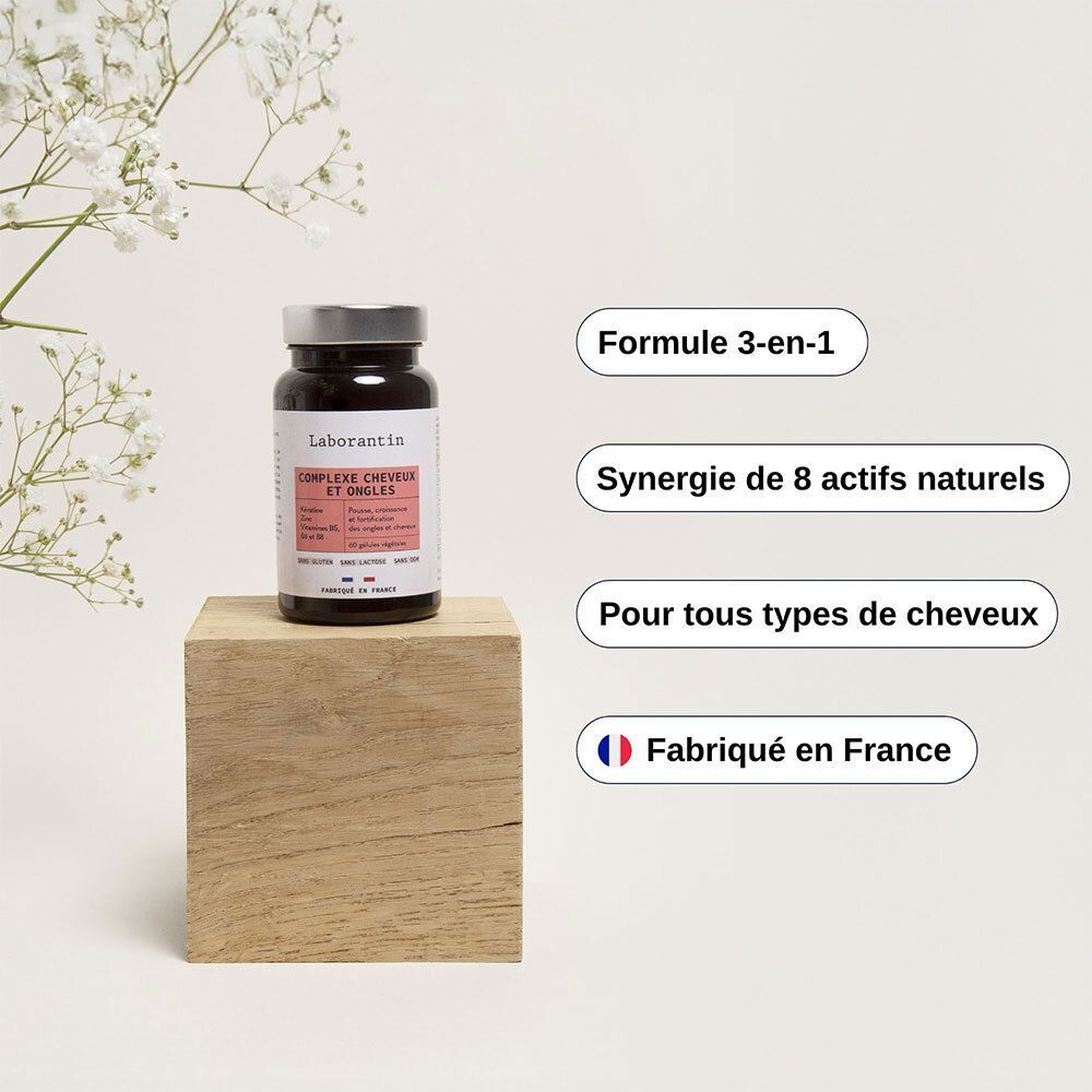 Flacon de gélules sur bloc de bois. Inscription: Laborantin Complexe Cheveux et Ongles. Texte: Fabriqué en France.