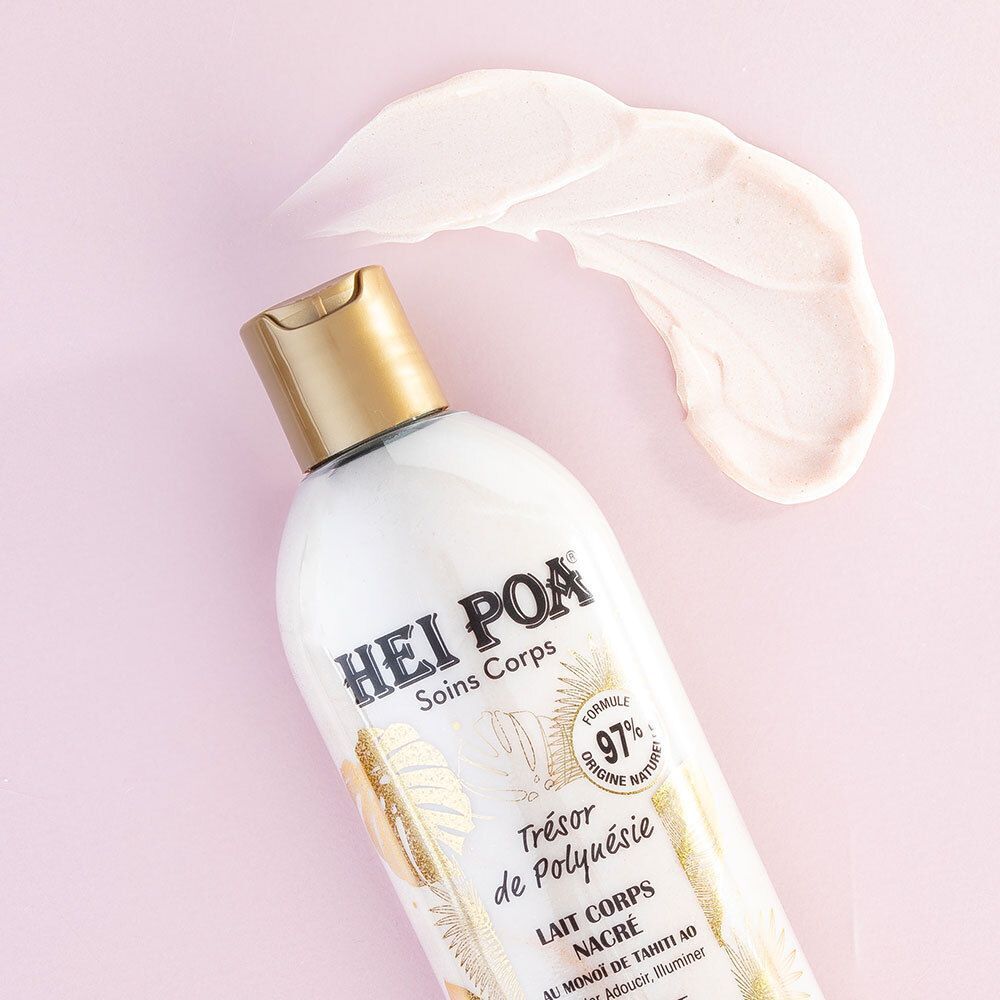 Flacon avec bouchon doré et échantillon de produit sur fond rose. Inscription: HEI POA, Soins Corps, Trésor de Polynésie, Lait Corps Nacré, Sparkle Body Milk.