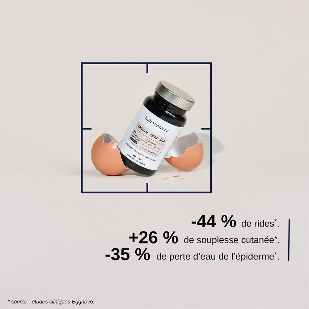 Flacon Laborantin Absolu Anti-Âge dans un cadre. Coquilles d'œufs cassées. Texte: +26% de souplesse cutanée.