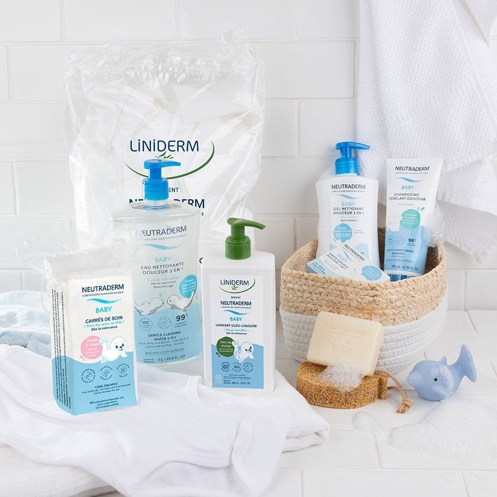 Une sélection de produits de soins pour bébés, dont des carrés, des lotions et du savon, sur une surface blanche. Différents emballages.