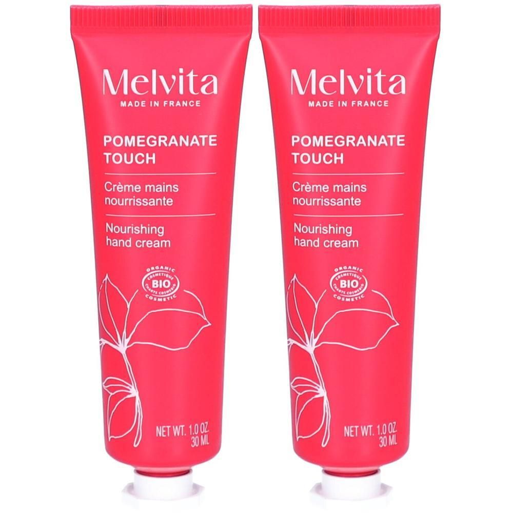 Deux tubes de crème pour les mains. Tubes roses avec texte blanc. Inscription : Melvita, Pomegranate Touch, Crème mains nourrissante, Nourishing hand cream.