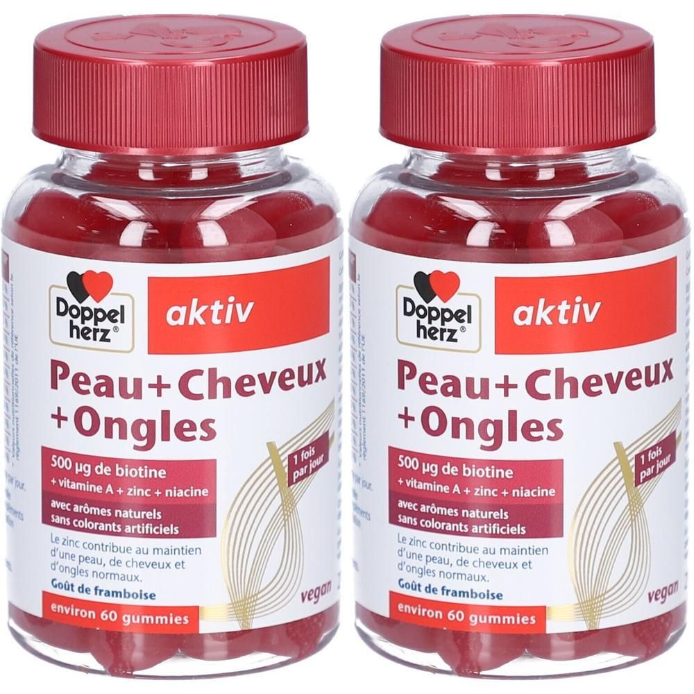 Deux flacons de Doppelherz aktiv Peau+Cheveux+Ongles. Bouchons rouges, contenants transparents avec gummies rouges. Inscription: 500 µg biotine, zinc, vitamines.