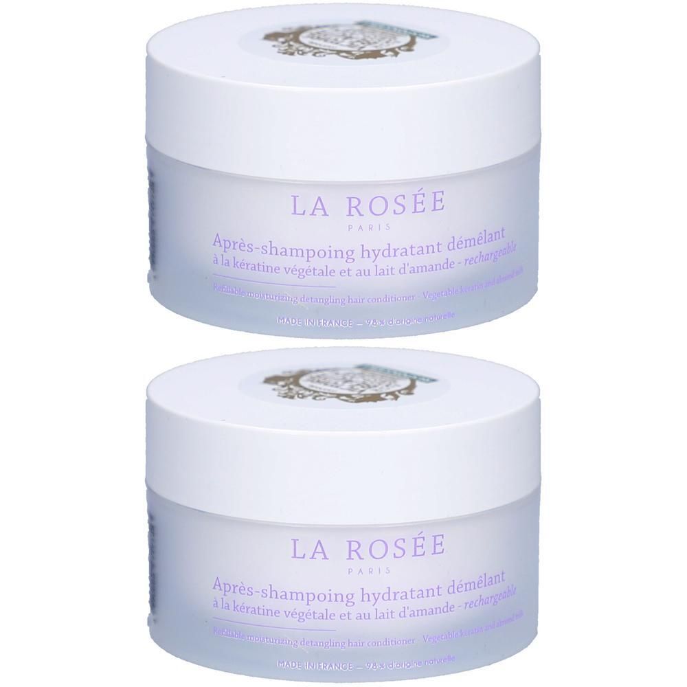 Deux pots blancs avec couvercles. Inscription: LA ROSÉE. Texte violet: Après-shampoing hydratant demêlant. Avec kératine et amande.