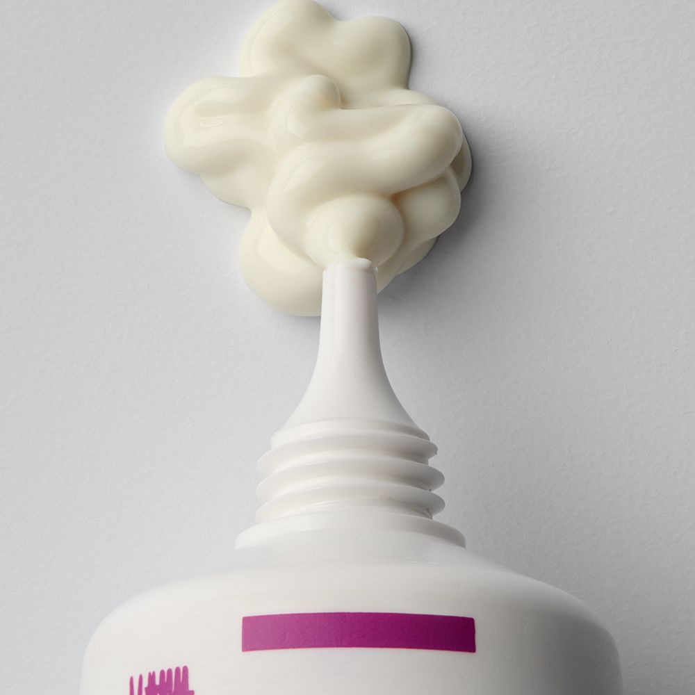 Gros plan de l'ouverture d'un tube Isispharma Cicapro Cream SPF50+ avec une portion de crème.