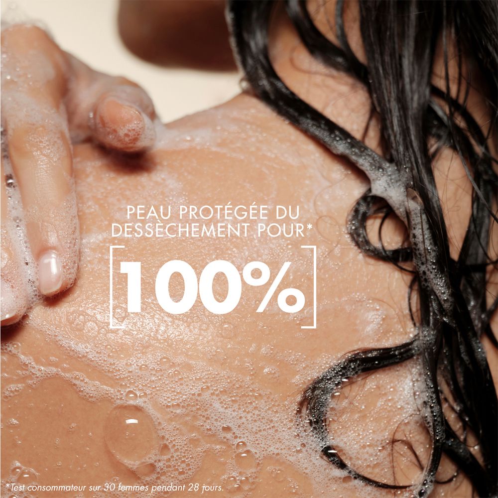 Gros plan d'une épaule avec mousse et gouttes d'eau. Texte : "PEAU PROTÉGÉE DU DÉSSÉCHEMENT POUR 100%".