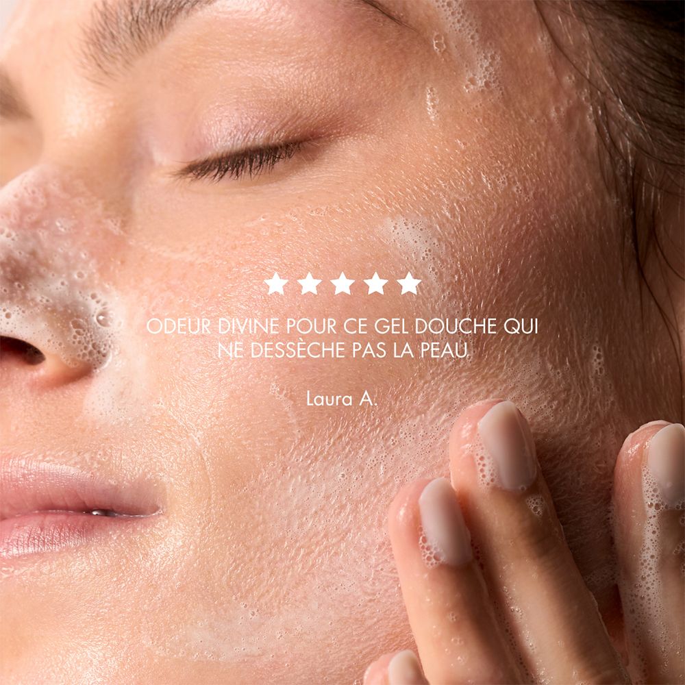 Gros plan d'un visage couvert de mousse. Cinq étoiles et texte : "ODEUR DIVINE POUR CE GEL DOUCHE QUI NE DÉSSÈCHE PAS LA PEAU".