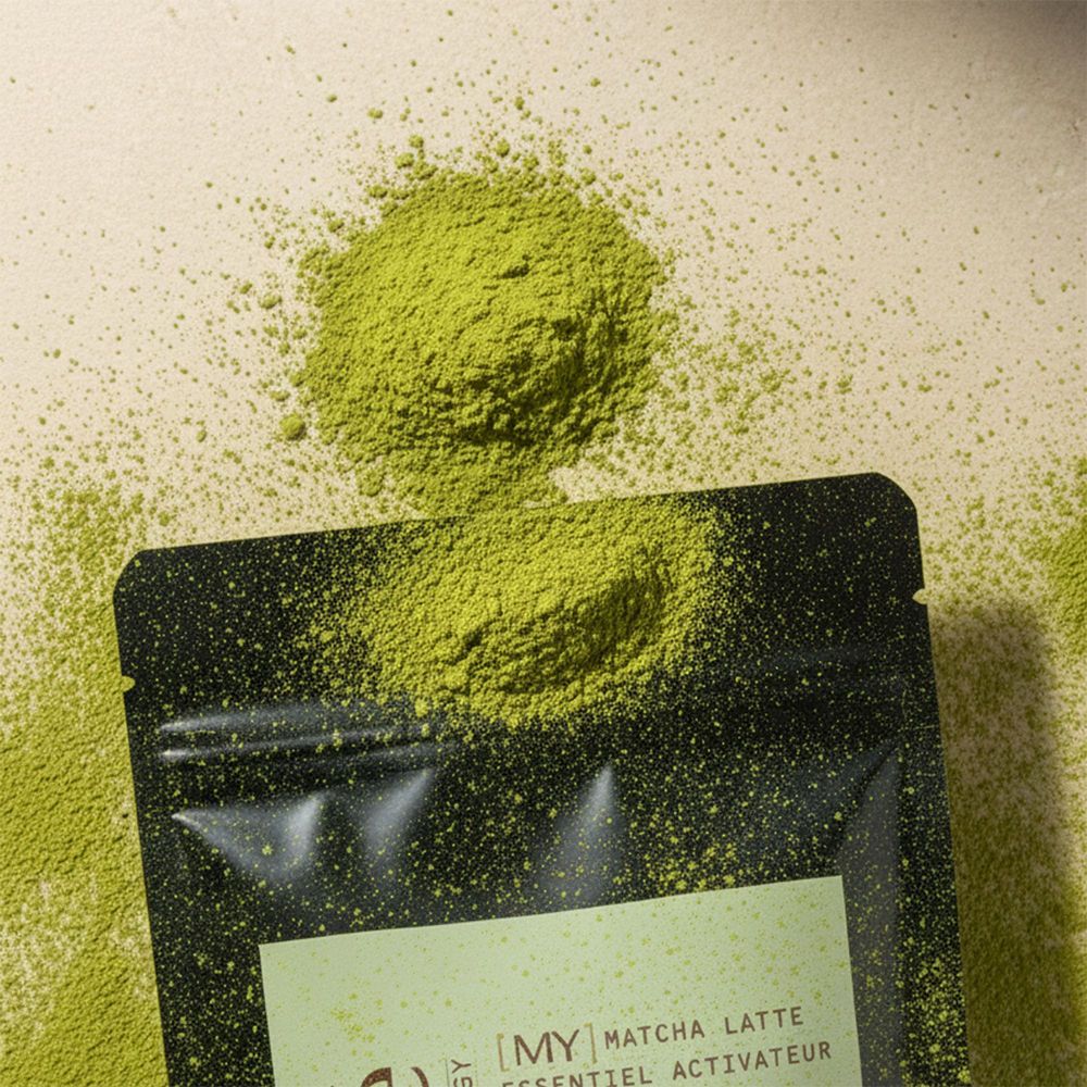 Poudre Miyé Matcha Latte, partiellement dispersée sur un sachet noir.