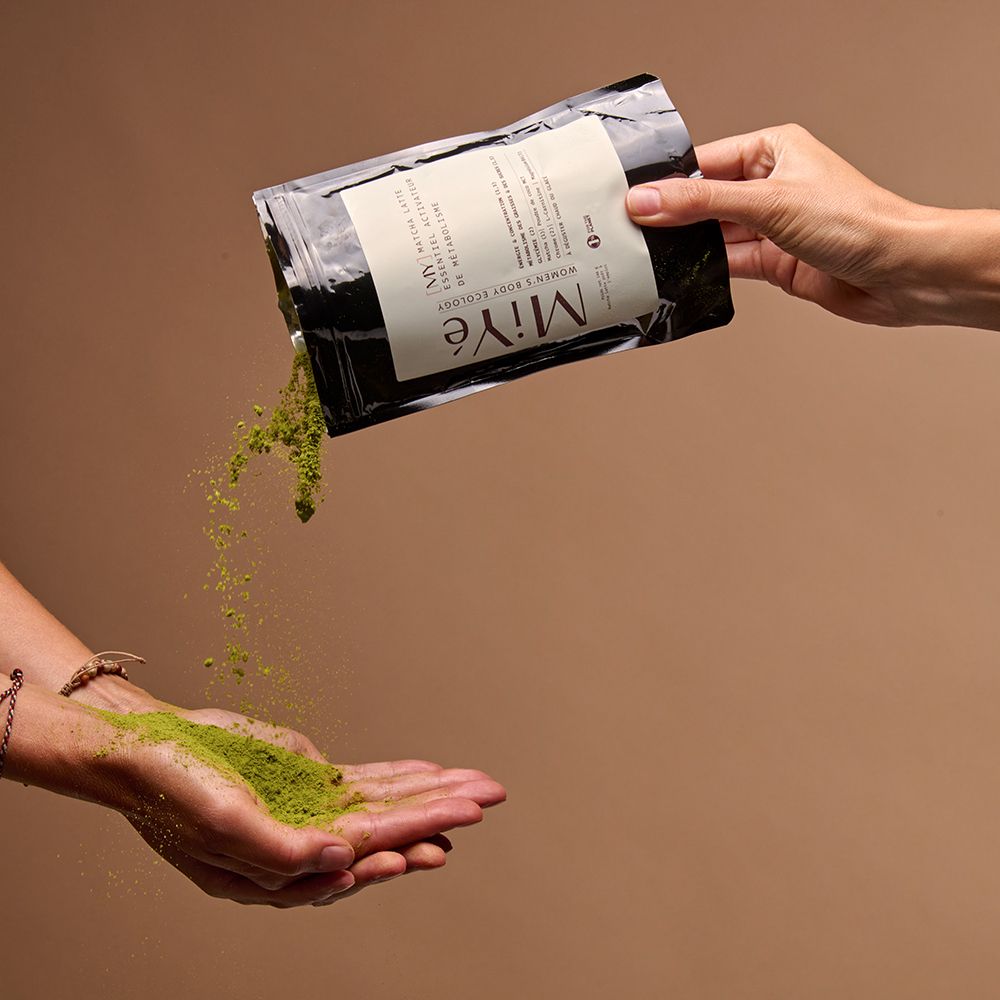 Poudre Miyé Matcha Latte versée d'un sachet dans une main.