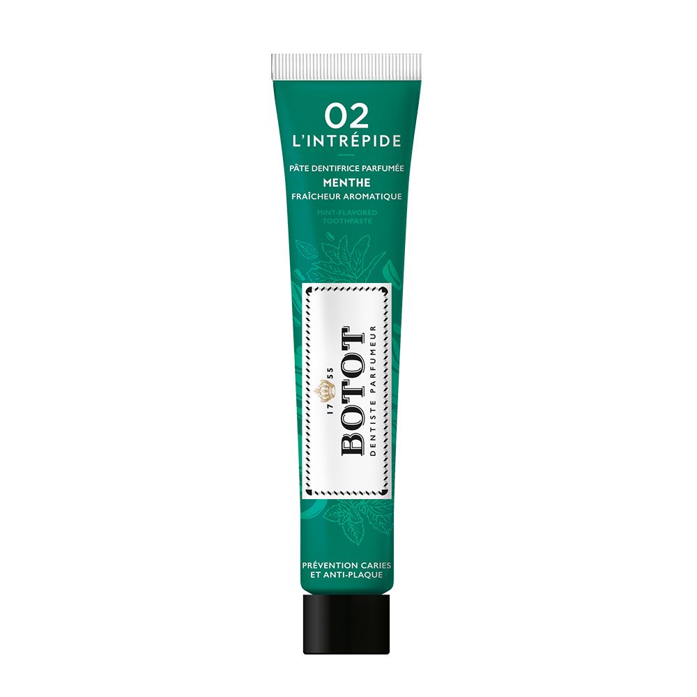 Tube de dentifrice vert avec étiquette blanche et motif de feuilles de menthe. "BOTOT L'INTRÉPIDE 02" et "PÂTE DENTIFRICE PARFUMÉE MENTHE" sont imprimés.