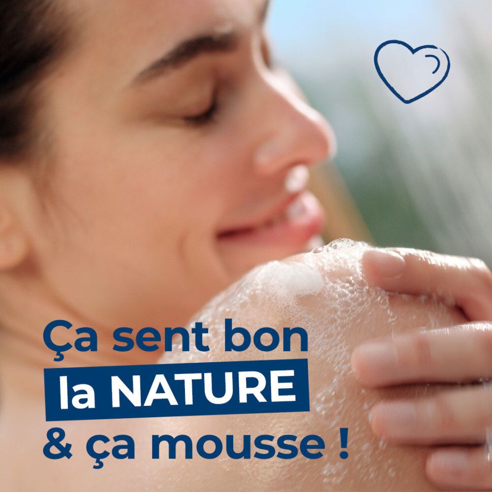 Femme sous la douche avec de la mousse.