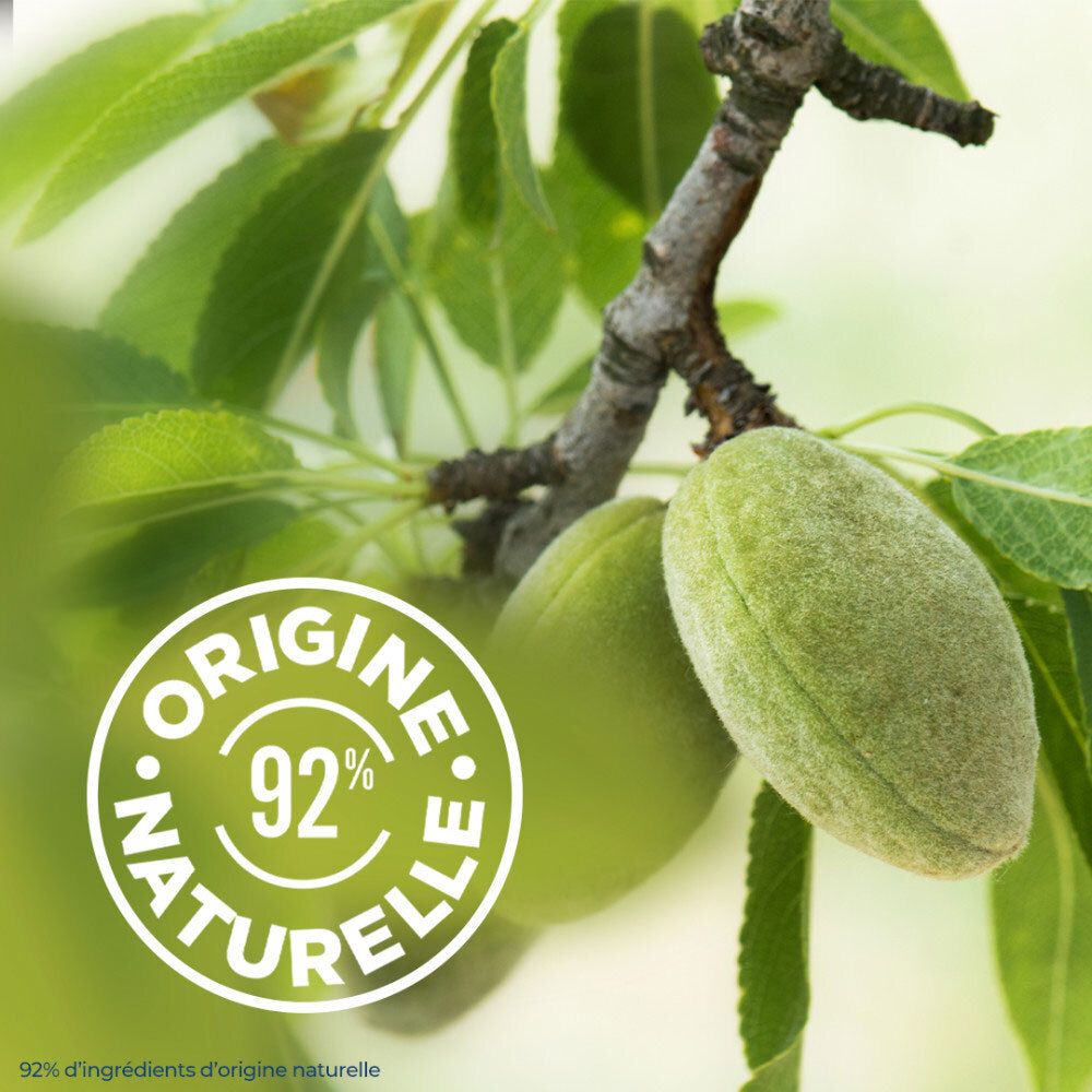 Amandes vertes sur un arbre avec sceau '92% origine naturelle'.