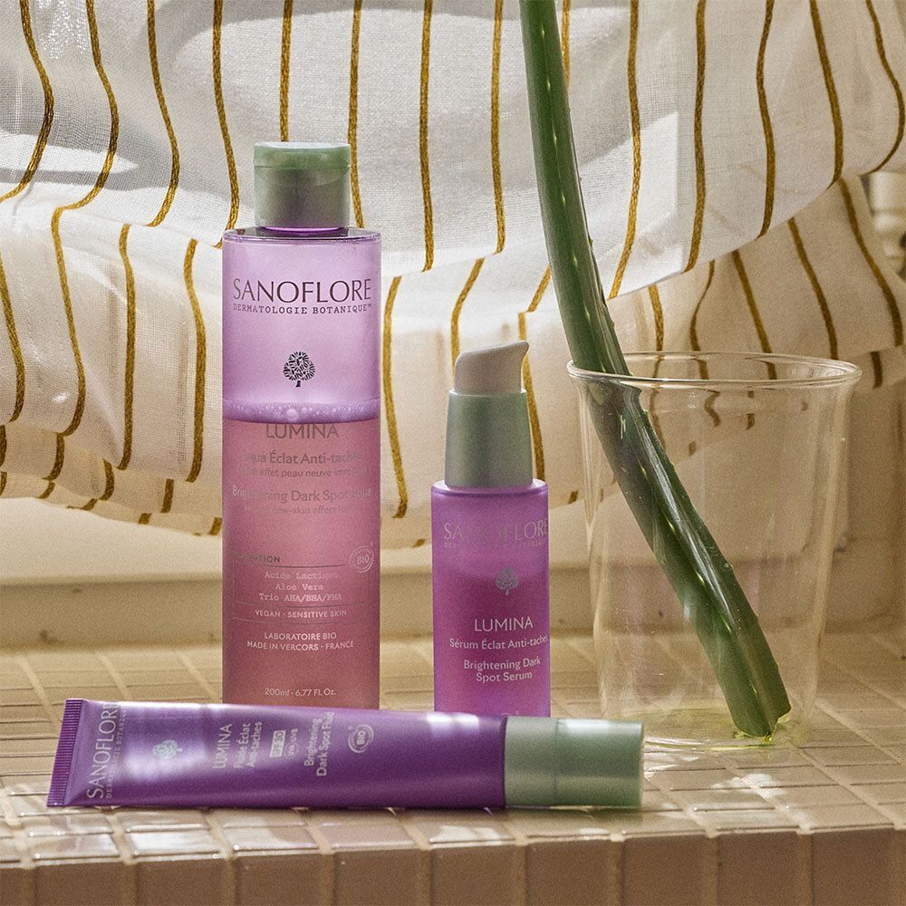 Divers produits Sanoflore sur une surface carrelée. Dont un tube Lumina.