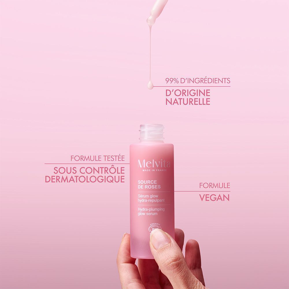 Flacon rose avec pipette, main. Inscription: Melvita, Source de Roses, Sérum glow hydra-repulpant, Bio. 99% ingrédients naturels.