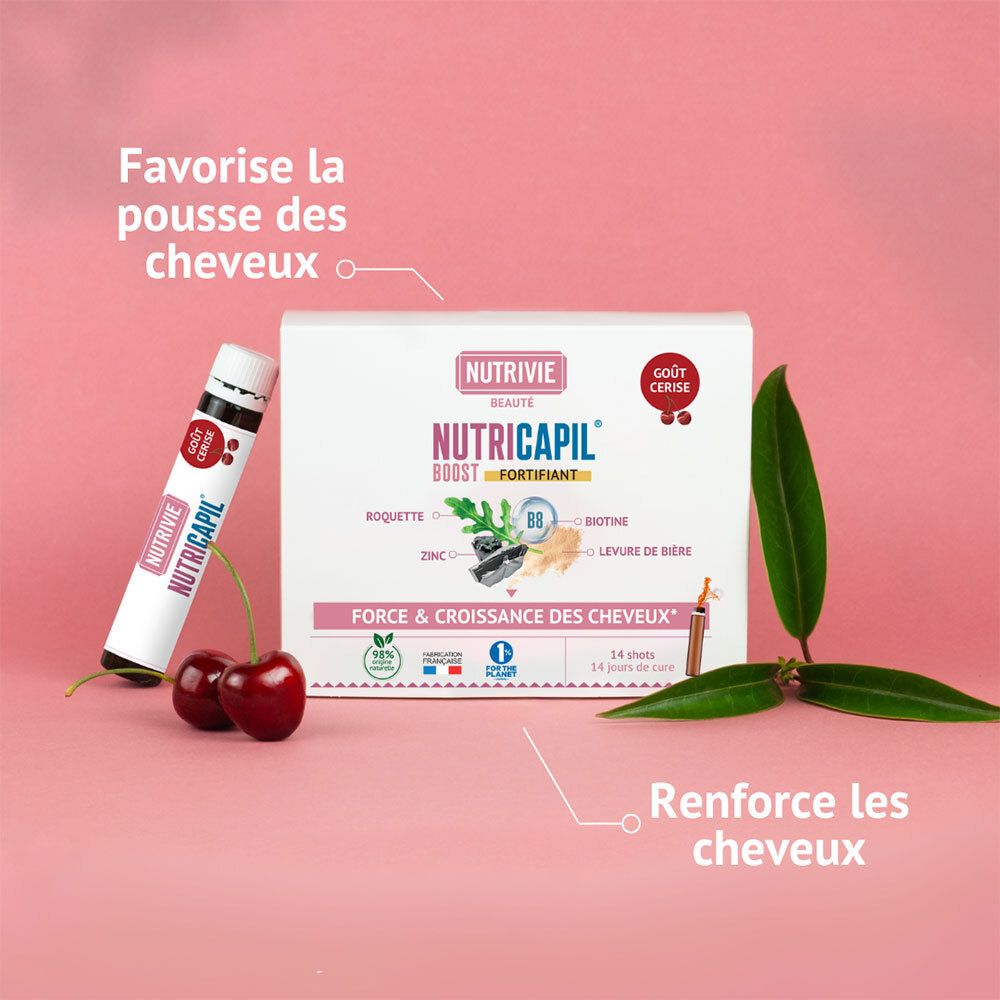 Boîte et un shot NUTRIVIE NUTRICAPIL BOOST. Cerises et feuilles au premier plan.