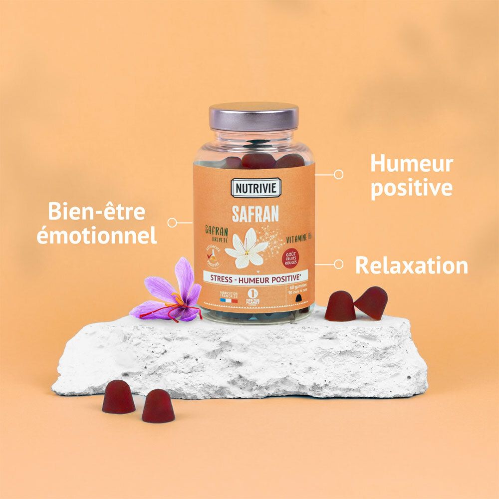 Bouteille Nutrivie Safran Gummies sur pierre, avec gummies et fleur de safran.