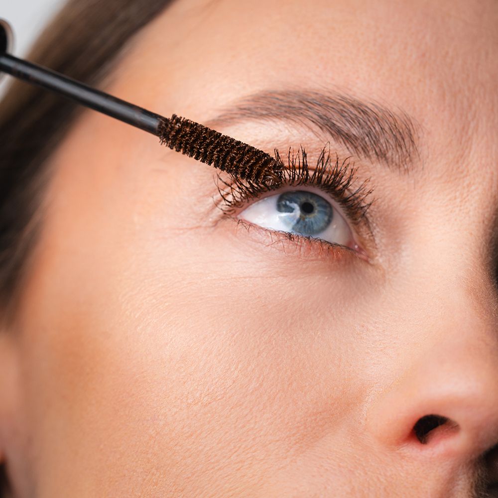 Applicateur de mascara brun appliqué sur les cils.