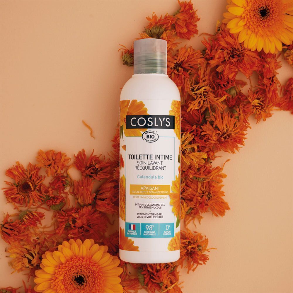 Flacon blanc avec étiquette jaune, entouré de fleurs oranges. Texte: COSLYS BIO, TOILETTE INTIME, Calendula bio.