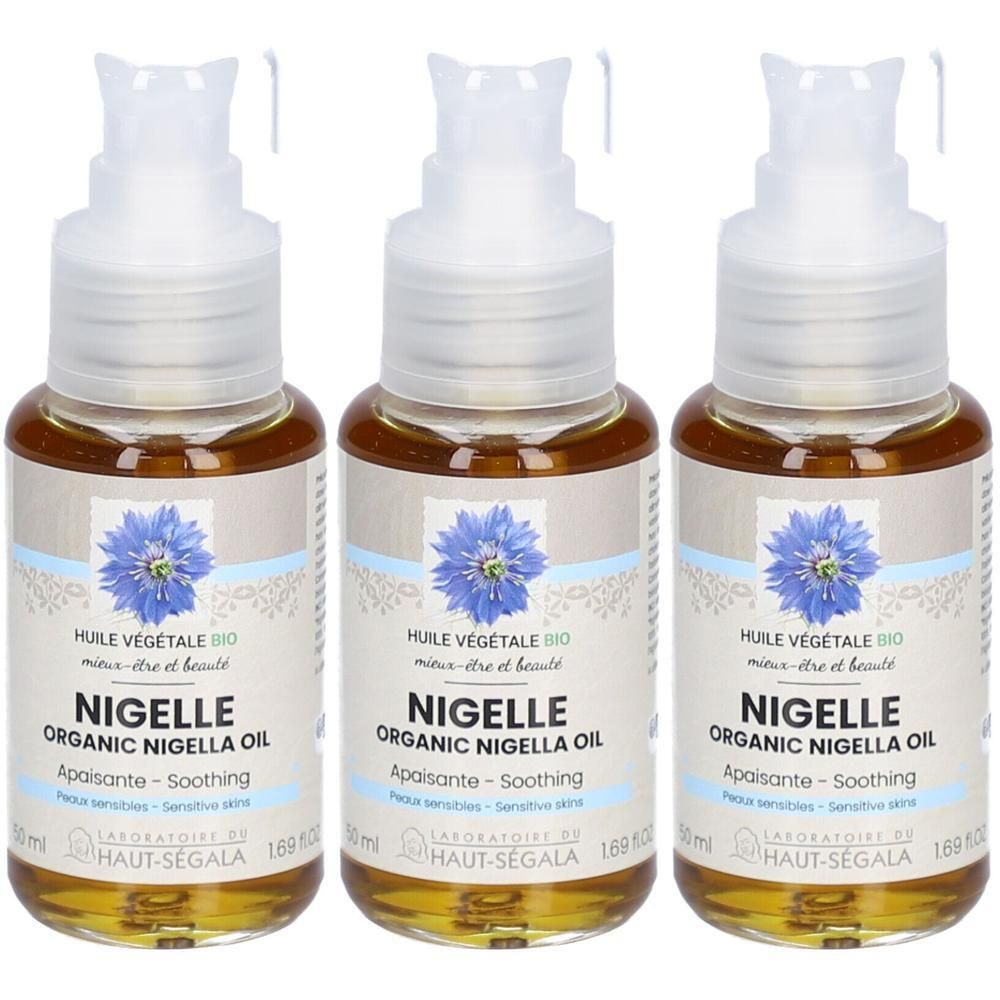 Trois flacons avec pompe. Inscription: NIGELLE ORGANIC NIGELLA OIL. Étiquette avec fleur bleue. Marque: HAUT-SEGALA.