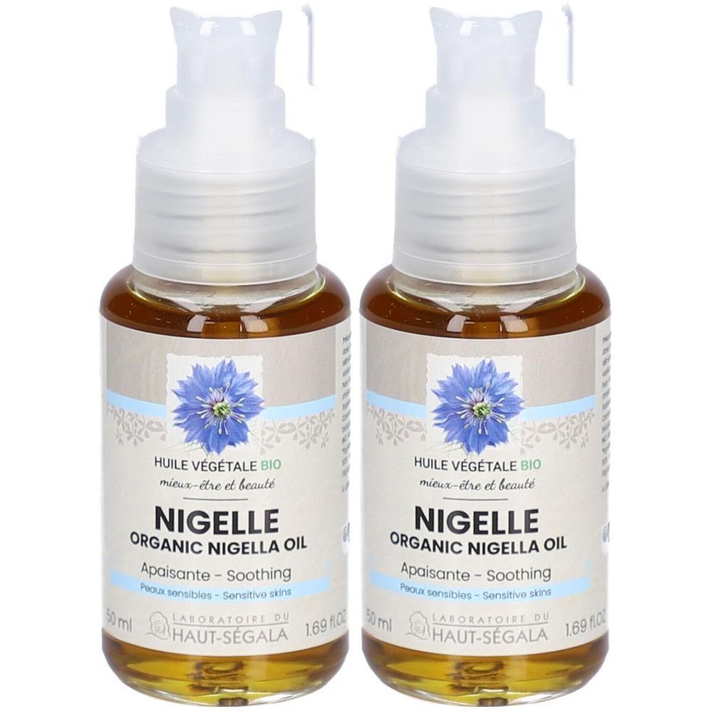 Deux flacons d'huile végétale avec pompe. Étiquettes avec "Nigelle Organic Nigella Oil" et une fleur bleue. Marque: HAUT-SEGALA.