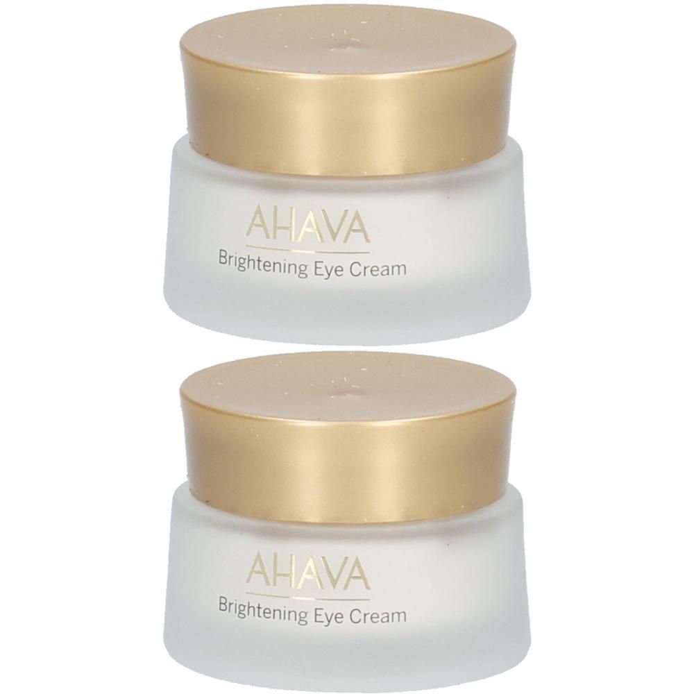 Deux pots de crème avec des couvercles dorés. On peut lire AHAVA Brightening Eye Cream sur les pots.