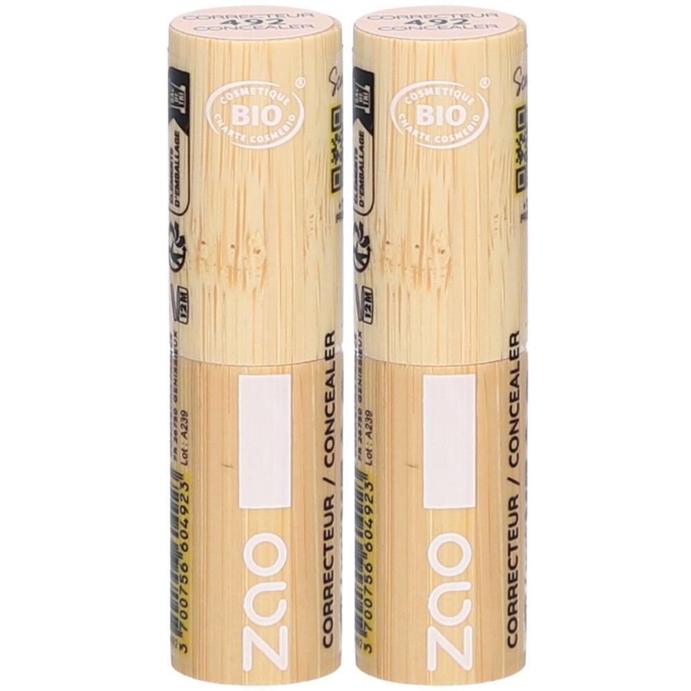 Deux correcteurs beige clair. Capuchon en bois clair. Inscription: ZAO CORRECTEUR / CONCEALER, certification BIO.
