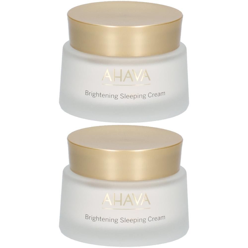 Deux pots avec couvercles dorés. Sur les pots blancs, le nom AHAVA et Brightening Sleeping Cream sont visibles.