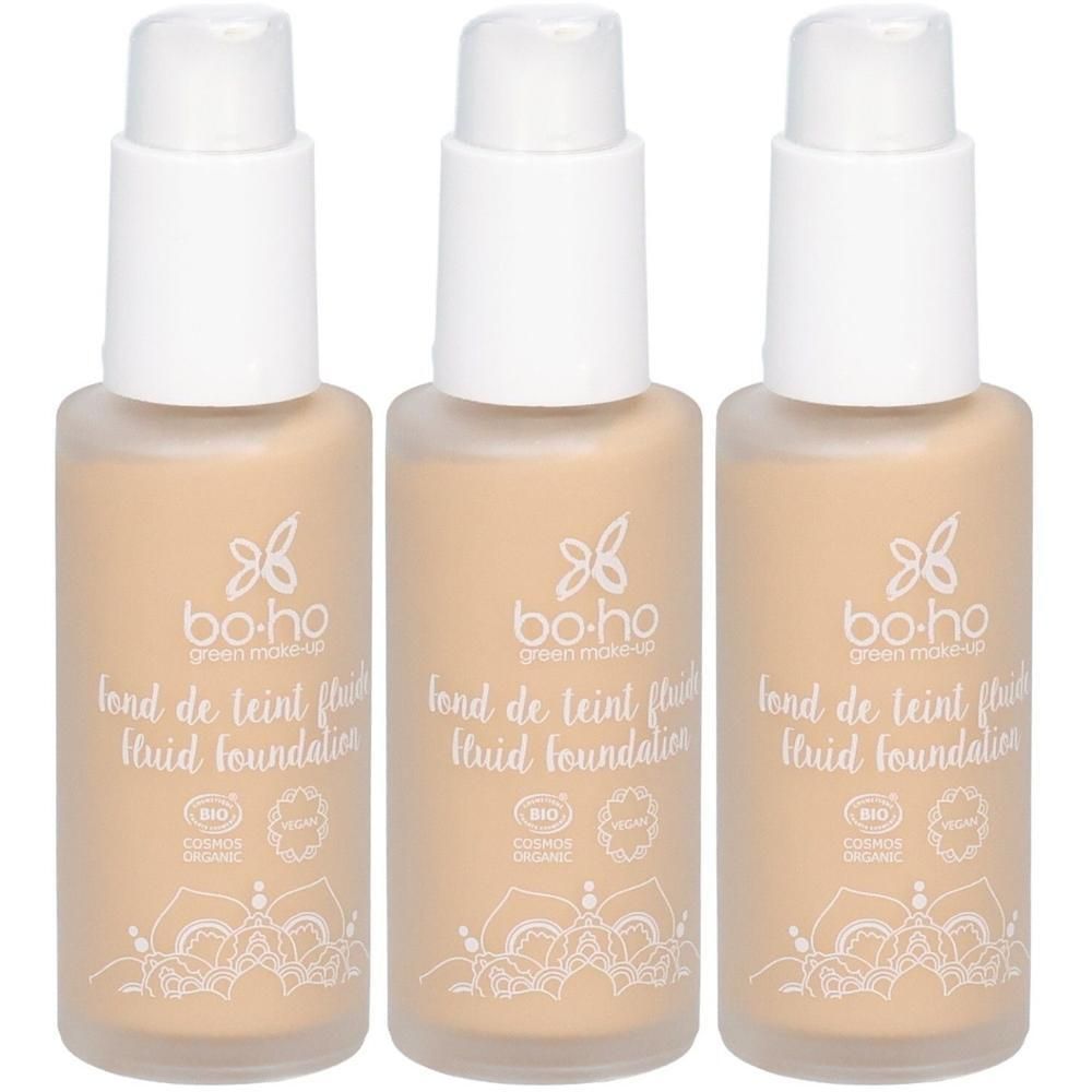 Trois flacons de fond de teint clair. Pompes blanches, liquide beige. Inscription : bo-ho green make-up, fond de teint fluid foundation, BIO.