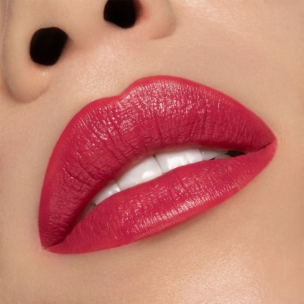 Gros plan sur des lèvres maquillées avec un rouge à lèvres rouge. Les lèvres sont brillantes.