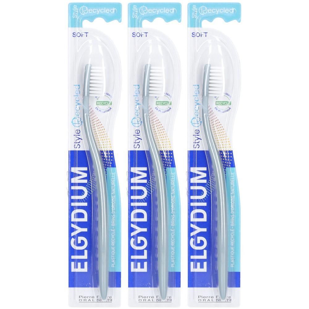 Trois brosses à dents emballées. Marque ELGYDIUM, modèle Style Recycled. Manches bleues, soies blanches. Emballage avec logo recyclé.