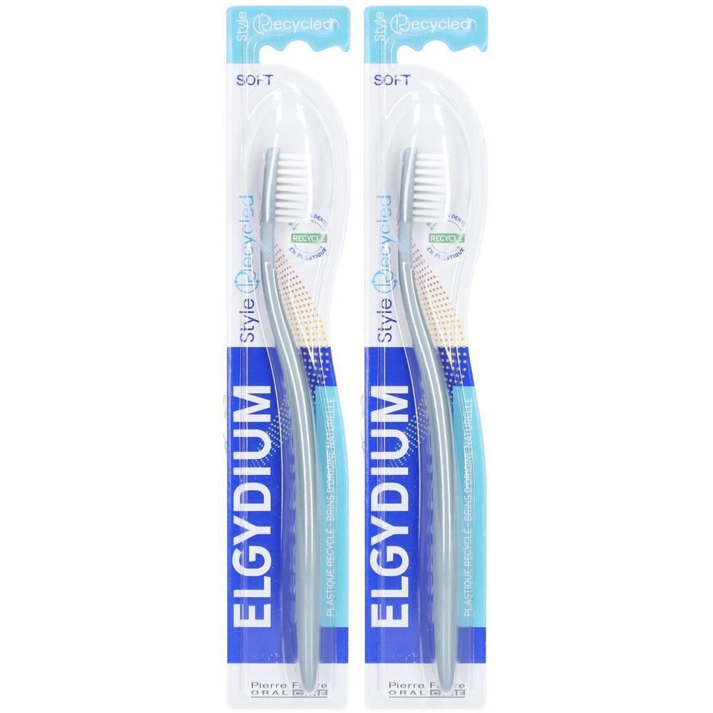 Deux brosses à dents sous blister. Les brosses ont un manche bleu et des poils blancs. Inscription : ELGYDIUM.