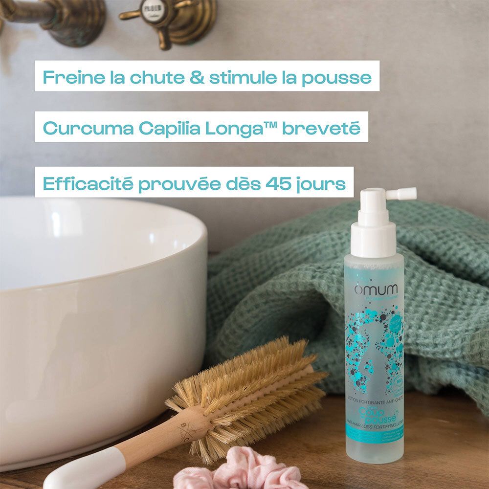 Flacon pompe 'Duo Pousse' d'Omum près d'une vasque. Texte français : 'Freine la chute'.