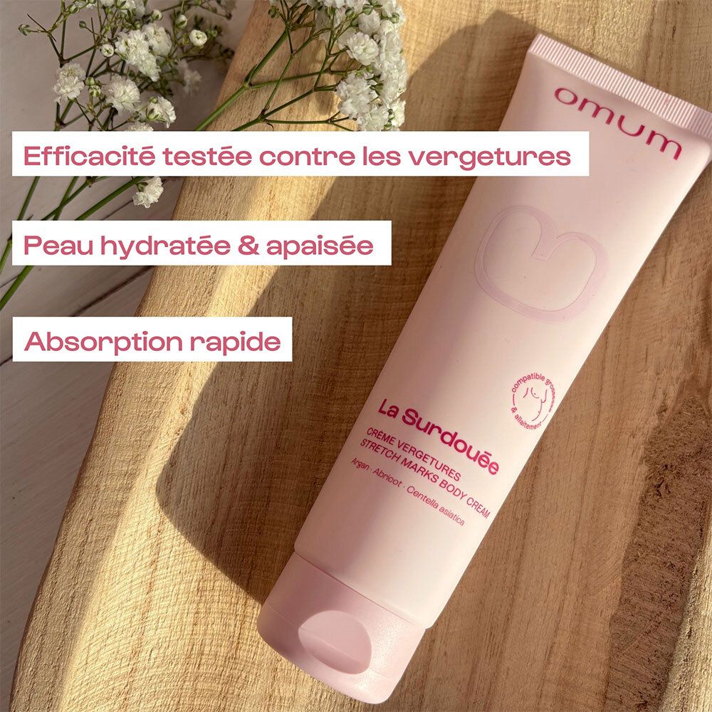 Tube rose pâle Omum La Surdouée Crème Corps Vergetures sur fond de bois, avec zones de texte.