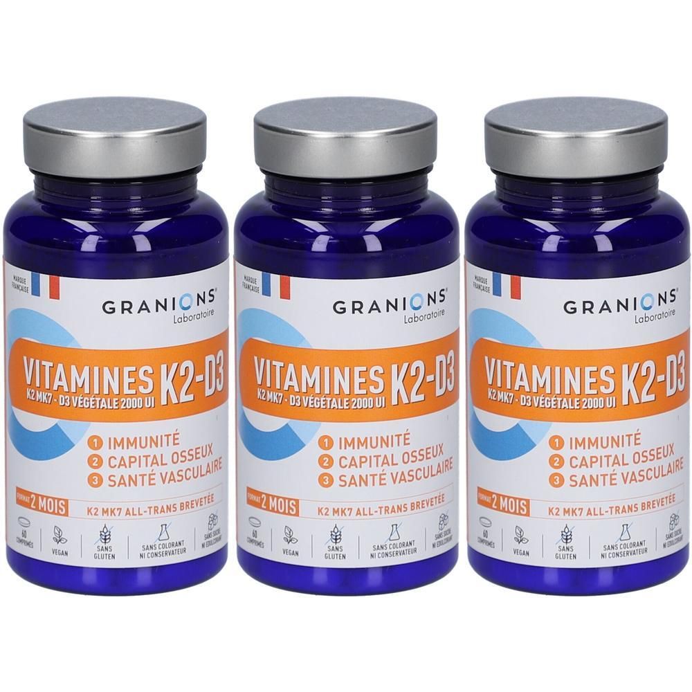 Trois flacons de Granions Vitamine K2-D3 avec bouchons à vis argentés. Étiquettes bleues avec inscriptions blanches et oranges.