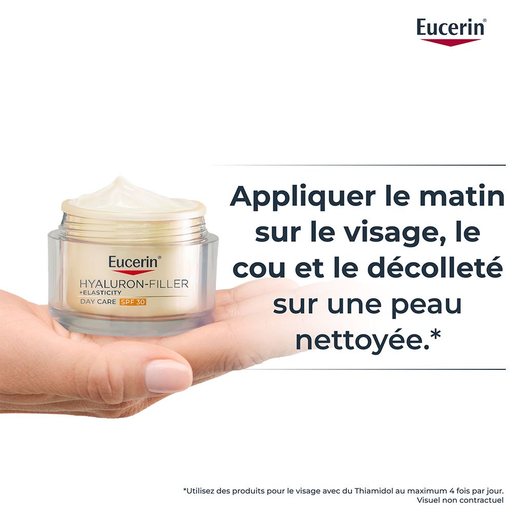 Main tenant Eucerin Hyaluron-Filler + Elasticity Soin de Jour SPF 30 sur peau propre.