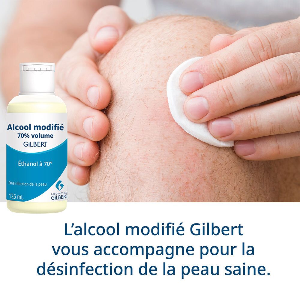 Personne désinfectant un genou avec un coton et de l'alcool. Flacon: Alcool modifié 70% volume Gilbert.