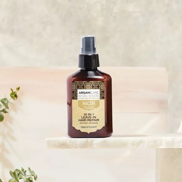 Arganicare spray réparateur sans rinçage. Flacon marron avec vaporisateur noir. Étiquette avec informations produit.