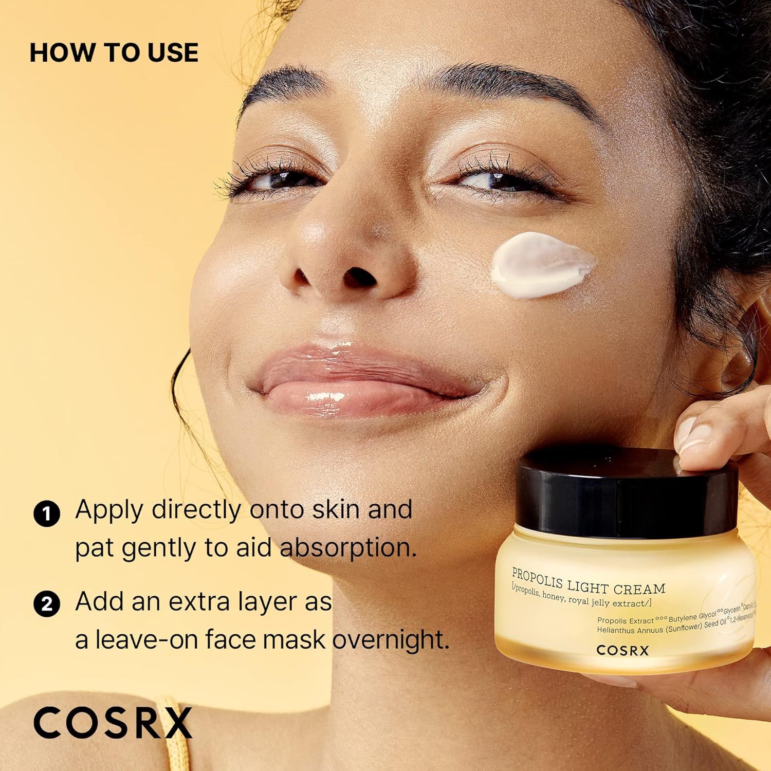 Une femme avec de la crème légère Propolis COSRX sur la joue, tenant le pot.