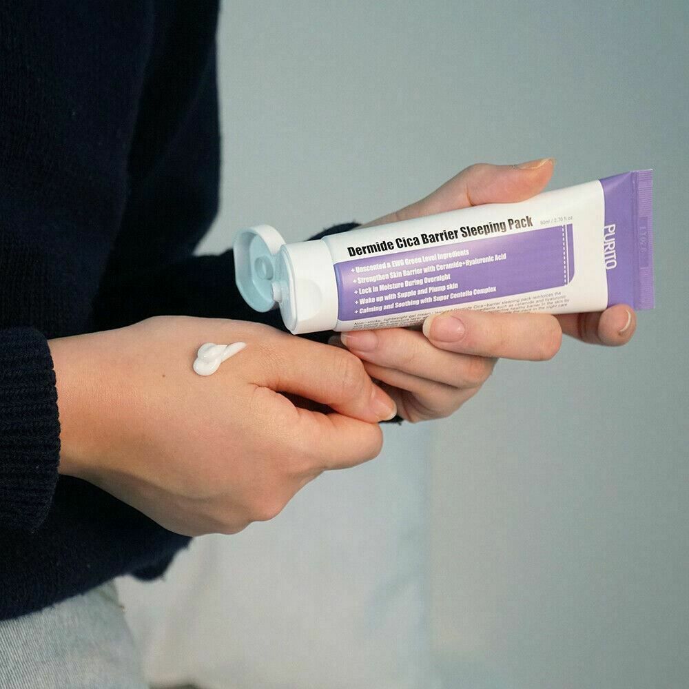 Mains tenant un tube. Crème appliquée sur la main. Texte: Dermide Cica Barrier Sleeping Pack.