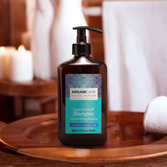 Flacon de shampooing antipelliculaire Arganicare, marron avec pompe noire. Étiquette turquoise avec texte.
