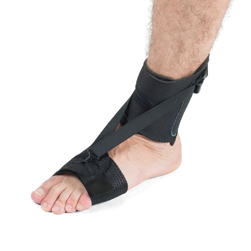 Orthèse de pied portée. Matériau textile noir, fermetures velcro et sangles. Fixée au pied.