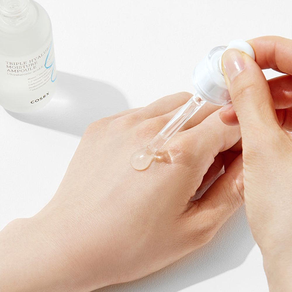 Ampoule d'hydratation triple hyaluronique COSRX appliquée sur une main.