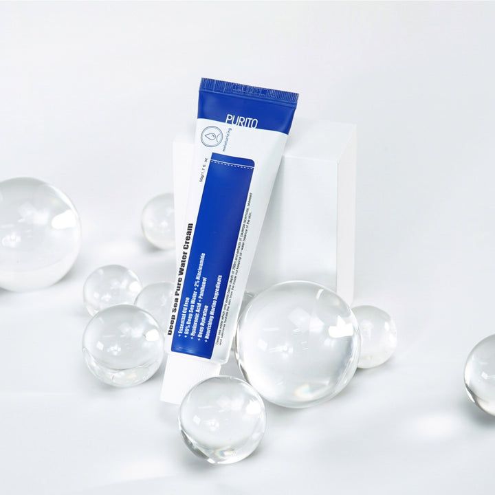 Tube sur socle blanc, entouré de boules de verre. Inscription : Deep Sea Pure Water Cream. Tube bleu et blanc, marque PURITO.