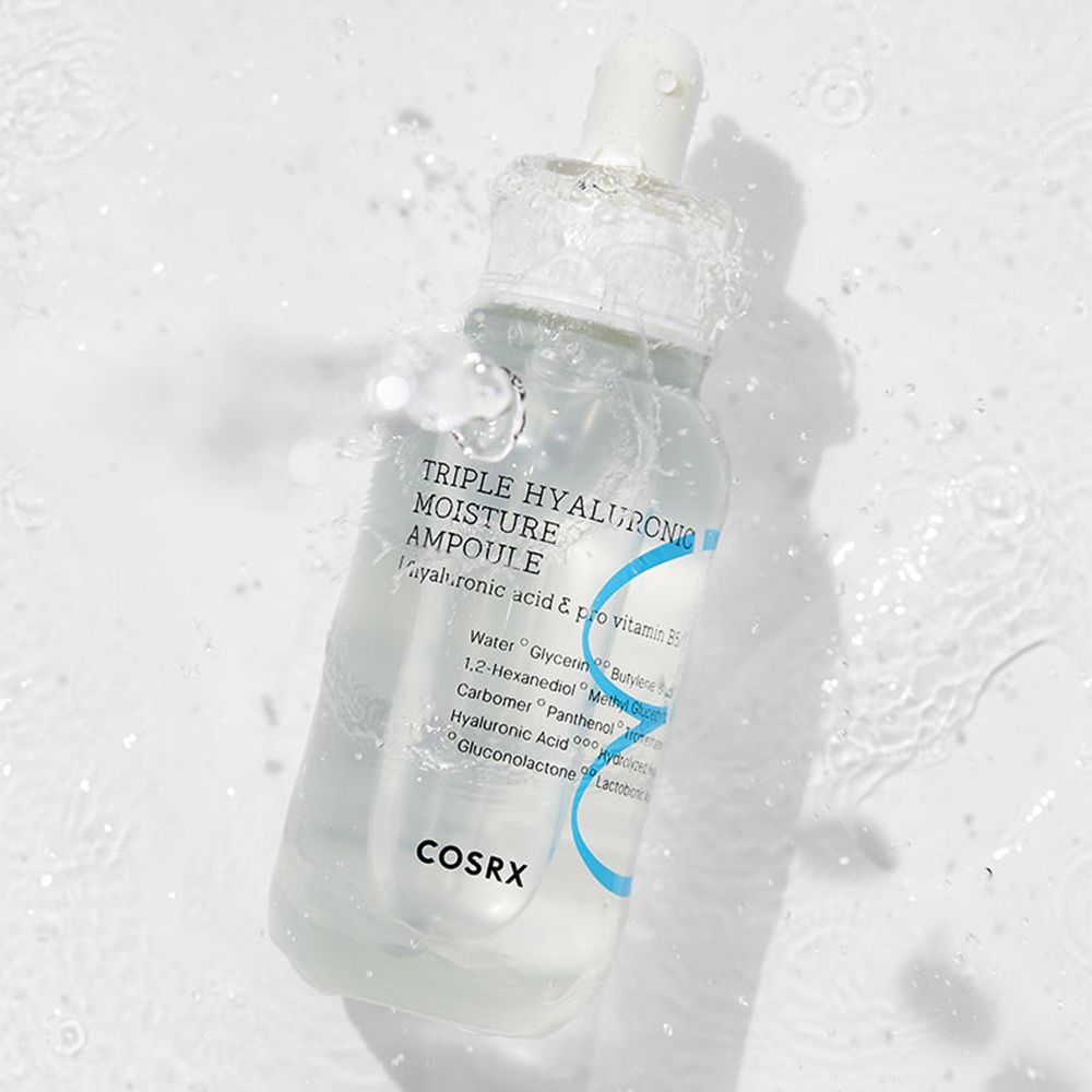 Ampoule d'hydratation triple hyaluronique COSRX avec pipette, entourée de flux d'eau.