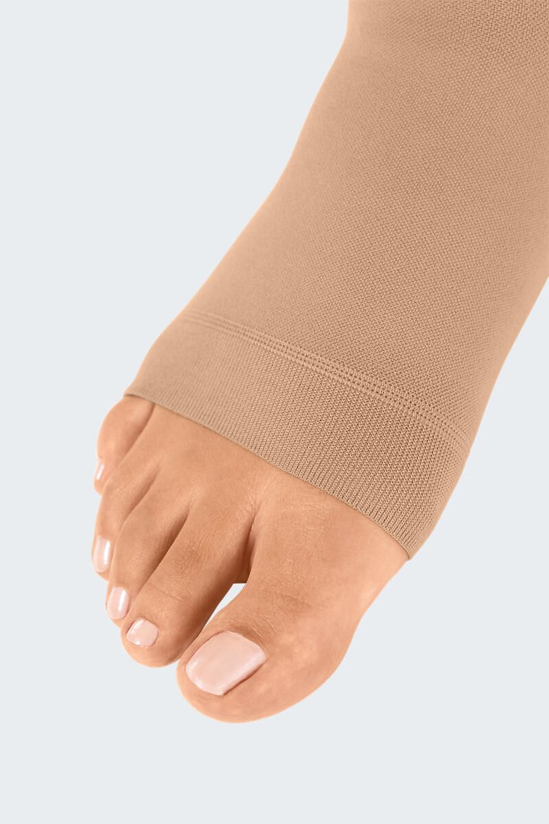 Bas de compression couleur chair, bout ouvert. Matière fine. Gros plan du pied.
