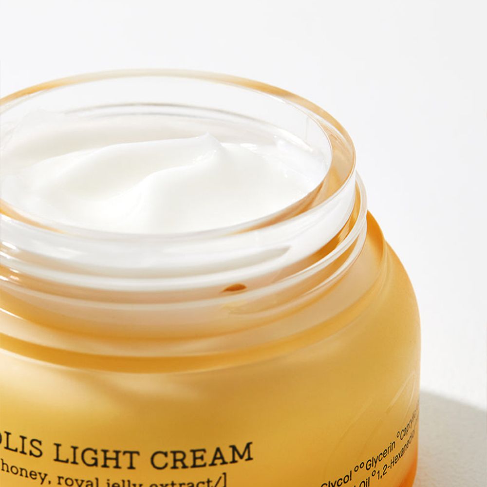 Gros plan de la crème légère Propolis COSRX dans un pot en verre.